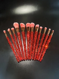 Detail of 12-piece makeup brush set featuring red rhinestones and pink gradient bristles