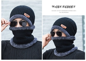 Close-up of black winter knitted hat and neck gaiter set with thick grey fleece lining