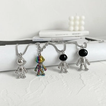 Detailed view of astronaut pendant necklaces in silver and rainbow titanium steel colors
