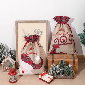 Linen Christmas gift bags with reindeer pattern and drawstring closure in a festive setting
