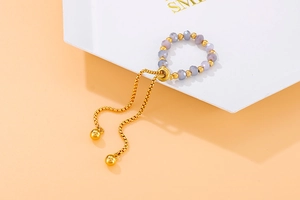Adjustable beaded ring with purple faceted crystals and gold steel box chain detail