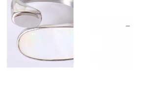Macro detail of oval white mother of pearl inlay on adjustable 18k gold steel ring