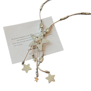 Bohemian leather cord necklace with hammered star pendant and tassels on decorative card
