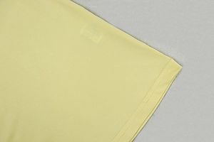 Close-up of pale yellow knit dress showing soft fabric texture and double-needle hem detail