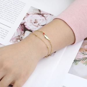 Gold double-layered Palestine map bracelet with enamel pendant and gold beads on wrist