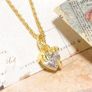 Macro view of a 18K gold plated copper heart pendant with clear cubic zirconia stone