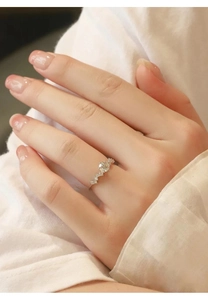 Close-up of sparkling moissanite wedding ring with side diamonds on model's hand