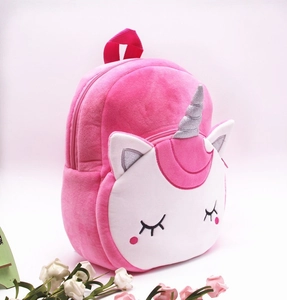 Detailed side view of plush unicorn backpack showing soft pink fabric and silver horn