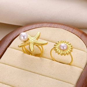 Gold stainless steel starfish and sunflower rings with pearls in a velvet jewelry box