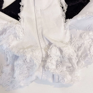 Gros plan détaillé sur les ourlets effilochés et le denim blanc vieilli du short d'été