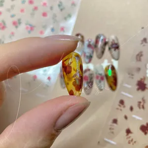Detail of amber textured press-on nails with glossy finish and floral design patterns