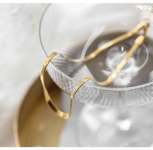 Minimalist 18K gold plated titanium steel flat snake chain necklace on glass cup