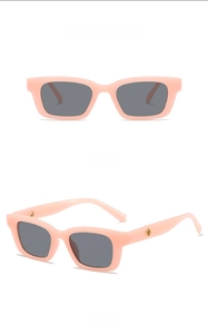 Detailansicht der rosa Kinder-Sonnenbrille mit grauen Gläsern und goldener Verzierung
