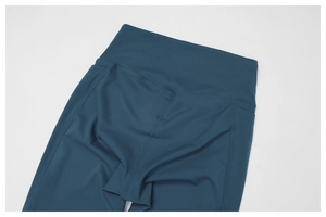 Detail view of high waist yoga pants with side pockets and flatlock seams in dark cyan
