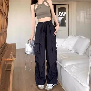 Women's black cargo pants with wide leg fit and olive green crop top in home setting