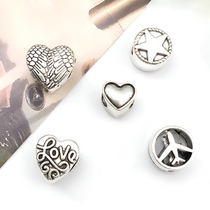 Detailed view of five vintage silver alloy charms featuring wings, stars, and hearts