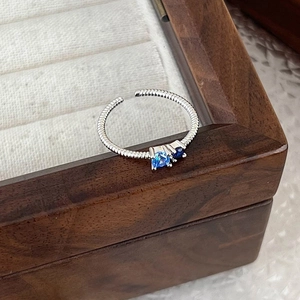 Macro detail of silver twist rope ring featuring two prong-set blue zircon gemstones