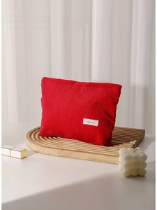 Red corduroy makeup bag with large capacity on a wooden tray for travel skincare