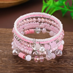 Dettaglio del bracciale multistrato bohémien con cristalli rosa e ciondolo a stella marina