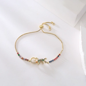 Gold-plated lizard bracelet with multicolor zircons on elegant white geometric props