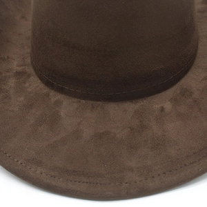 Detailed close-up of dark brown suede cowboy hat texture and fine decorative stitching