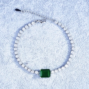 Luxury silver bracelet with green emerald cut gemstone and pave diamond detailing