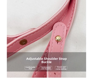 Detail of pink leather shoulder strap with golden adjustable metal buckle and white stitching