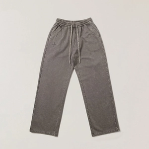Dettaglio dei pantaloni cargo grigi lavati con coulisse in vita e ricamo del logo laterale