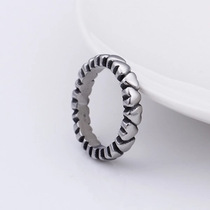 Detail shot of a vintage stainless steel ring with continuous heart leaf pattern on ceramic
