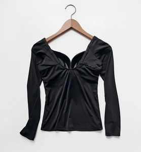 Detail view of a black long-sleeve slimming top with deep V-neck and built-in bra pads
