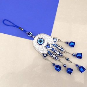 Vintage Hamsa Hand and Evil Eye wall hanging with blue bells and metallic ornaments