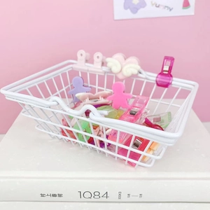 Close-up of white mini wire basket with various colorful decorative heart plastic clips