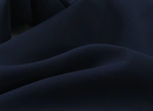 Vue détaillée de la texture du tissu bleu foncé et du tissage lisse de ce pantalon décontracté