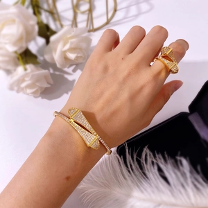 Close-up of a model wearing a gold fan-shaped bracelet and ring set with pavé crystals