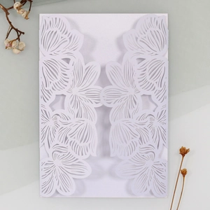 Detail of laser-cut white rose floral pattern on high-quality wedding invitation sleeve