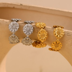 Gros plan des boucles d'oreilles marguerites en or et argent sur support céramique