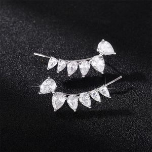 Detailed view of silver ear crawlers with gradient pear-cut cubic zirconia on black background