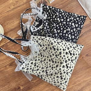 Detailed close-up of floral canvas tote bag with delicate lace bow shoulder straps