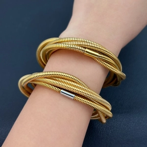 Detail of multi-layer 18K gold plated spring coil bracelet with snake bone texture