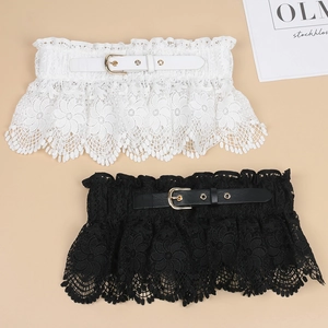 Close-up of elegant black and white lace waist belts with metallic gold buckles