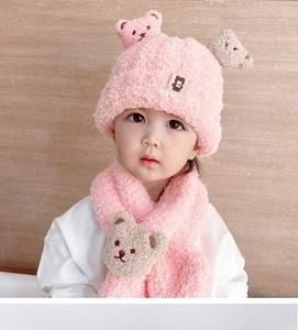 Detailed texture of pink plush knitted baby hat and scarf set with cute bear design