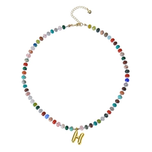 Detail of bohemian colorful beaded necklace featuring a golden bubble letter H pendant