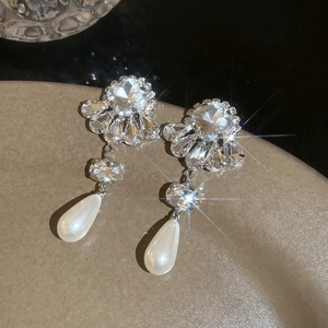 Macro detail of flower pearl earrings with crystals on ceramic base, shiny silver finish