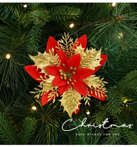 Close-up of red sequined poinsettia flower ornament on a Christmas tree with warm lights