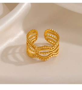 Close-up of golden multi-layer wave ring with bead texture on silk background