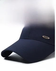 Detail of navy mesh baseball cap featuring a golden fashion tag and breathable fabric