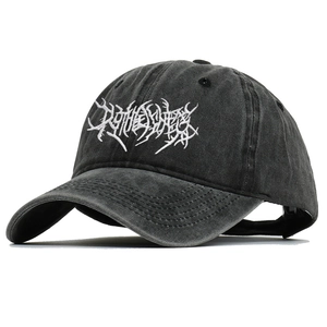 Detail of gothic white embroidery on washed black cotton baseball cap with vintage texture