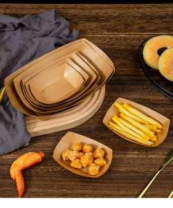 Disposable greaseproof kraft paper food trays in various sizes on a wooden table