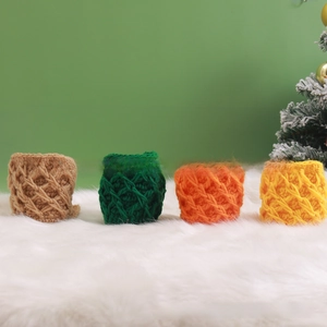 Macro view of handmade chunky knit mug sleeves in four festive colors on plush white rug