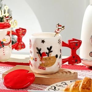 Christmas ceramic mug with red bow handle, reindeer lid and spoon set in festive setting